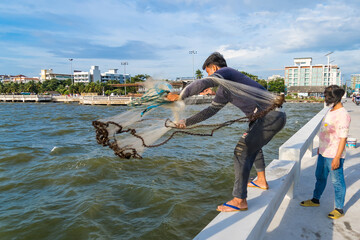 CHONBURI, THAILAND - October, 15, 2023: Unidentified name fisher man use fishing net fishing in the...