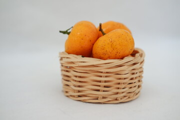 Fresh tangerines in a basket on white background, stock photo