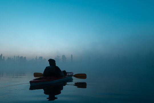 Person in a kayak, in the Xochimilco canal at dawn with fog