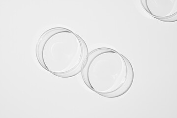 top view shot of a petri dish with liquid bubbles oil on a white background. hard lighting hard...