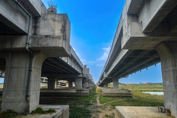 under a toll road bridge or highway with a bright blue sky