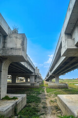 under a toll road bridge or highway with a bright blue sky