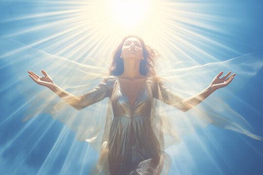 Beautiful woman in a golden dress raising her hands to the sun. Spiritual or religious concept.