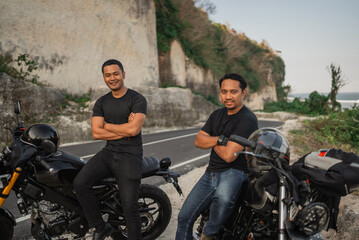 asian men sitting on motorcycle with crossed arms