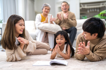 Portrait happy love asian family father and mother teach little daughter asian girl learn and study.Mom and asian young girl reading book making lessons in homeschool at home.Education