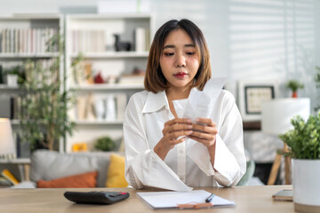 Obraz premium Smiling asian woman using calculator and calculate bills on laptop, paying bill, credit card, finance, tax, vat, credit card, payment, tax refund, budget, debt, money.financial and accounting concept