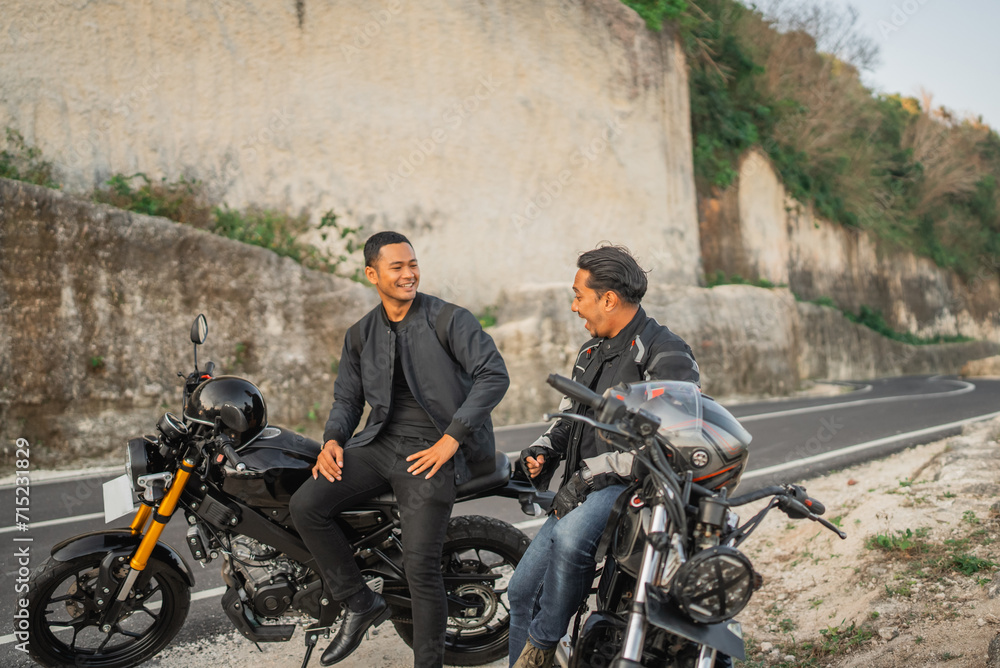 Wall mural indonesian riders wearing jacket sitting on motorbike spending time together