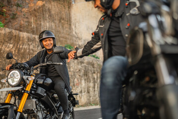 indonesian man riding motorbike with hand shake gesture