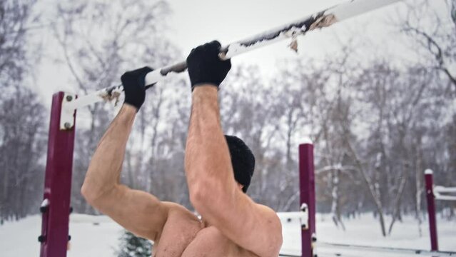 Slim hot sportsman do arm exercise outdoor gym. Half naked crazy guy training pull up bar. Work out day. Mad man fit train sport park. Cold winter fitness workout. Burn body fat hiit. Male nude torso.