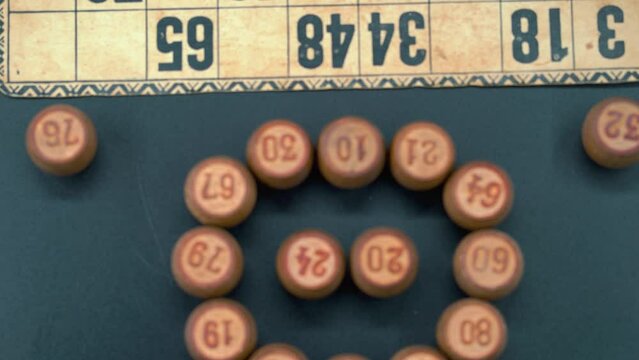 Cinematic close-up smooth zoom in shot from above of a Bingo wooden barrels in a circle, woody figures, old numbers background, vintage board game, professional lighting, slow motion 4K video