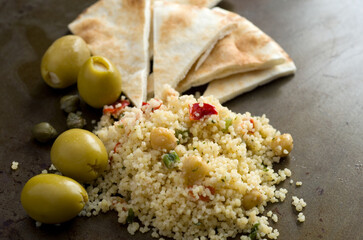 Macro Side View of Pita, Couscous, Olives, Capers and Chickpeas