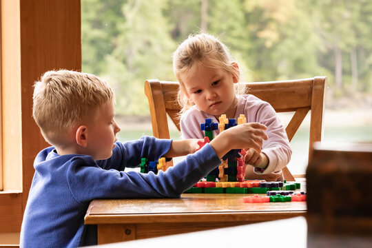 children brother sister playing with toys at home 