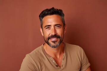 Portrait of a handsome man with a beard on a brown background.