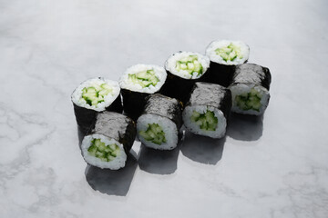 Classic japanese sushi rolls with fresh cucumber on a marble background