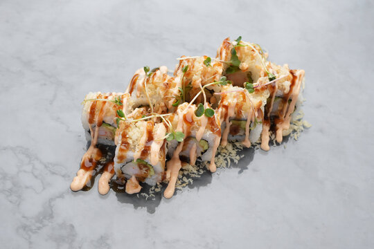 Japanese aburi maki roll with sauce on marble background