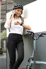 Confident businesswoman ride bicycle outside in downtown. Environmental conservation person commuting by cycling reduce carbon footprint. Bile to work, eco friendly alternative vehicle to green energy