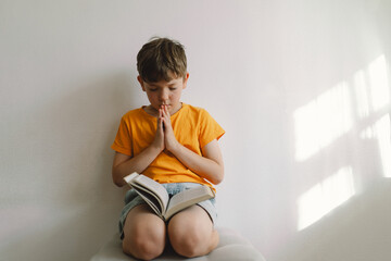 Christian boy holds bible in her hands. Reading the Holy Bible. Concept for faith, spirituality and religion. Peace, hope.