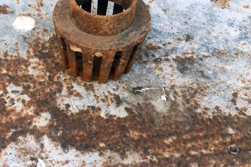 Rusty old metal gear on the background of a rusty iron sheet.