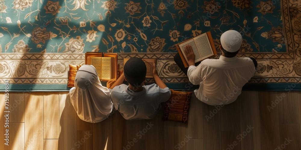 Wall mural back view muslim father, daughter and son sitting praying on sajadah prayer mat. holding read quran  - Wall murals