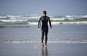 Ocean, surfing and man with surfboard at beach for waves on summer vacation, weekend and holiday by sea. Travel, nature and back of person running for water sports, adventure and hobby in Australia