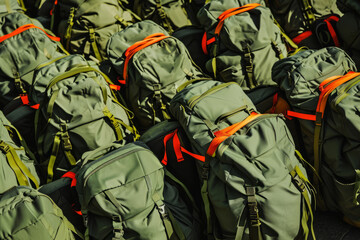 Regimented Display of Olive Green Backpacks with Orange Accents