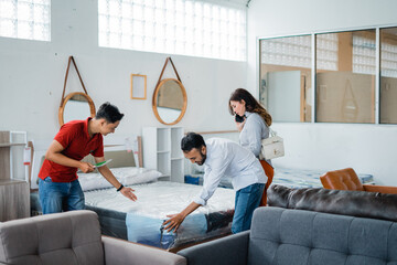 the male shop assistant offered the husband and wife about the new spring bed at the furniture store