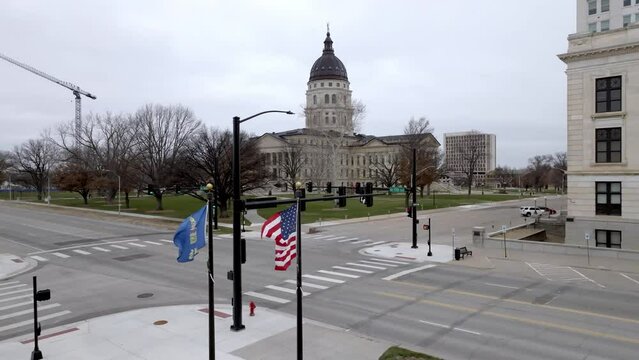 Kansas state capitol building with flags waving in wind in Topeka, Kansas with drone video stable.
