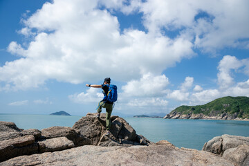 Hiker  jumping on seaside rock