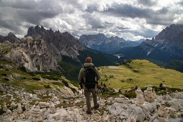 Fototapeta na wymiar Stunning view of a tourist on the top of a hill enjoying the view of the Cadini di Misurina