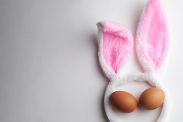 Bunny ears and chicken eggs on a white background