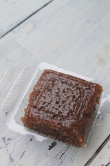 Indonesian food called wajik made of sticky rice and brown sugar in mica plastic on the table
