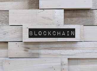 Wood copy space wall with text BLOCKCHAIN means technology system of recording information that...