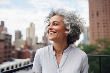 Portrait of smiling mature businesswoman standing on balcony in New York City