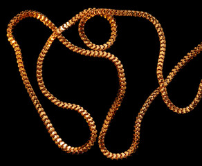 Gold chain isolated on black background. Close-up