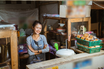 Asian girl stall seller standing relaxed with crossed hands with stall background
