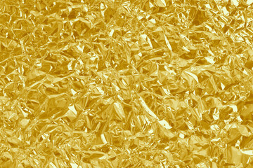 Gold foil leaf shiny texture, abstract yellow wrapping paper for background and design art work.