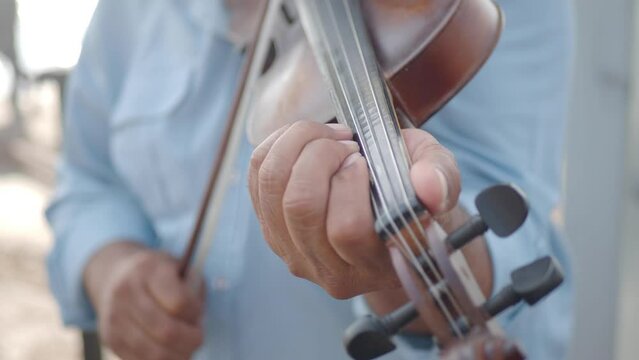 the hands of a classical musician violinist, playing music on the street 