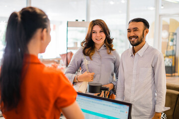 smiling couple buying goods and paying at the counter at a furniture store