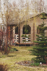 Fototapeta na wymiar early spring garden view in march or april. Rustic wooden house on background