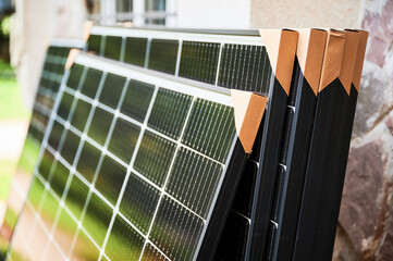 Close-up new solar panels with protective cardboard corners, ready for installation. Renewable...