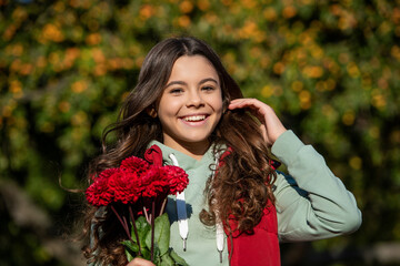 Naklejka premium positive teenager girl with autumn flowers bouquet. teenager girl with autumn flowers