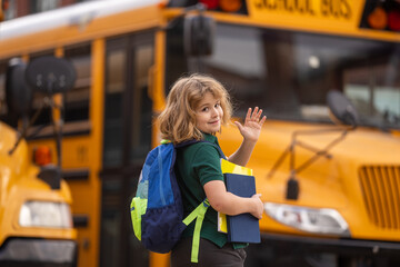 Education concept. Schoolkid with backpack and book getting on the school bus. American School....