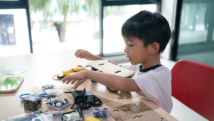 Portrait Of Happy Asian Student Building Arduino Robot Homework Project