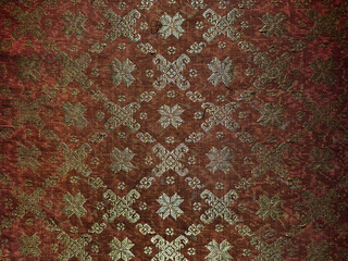 Royal Indonesian kingdom traditional ethnic batik seamless texture, in red and gold embroidery fabric color.