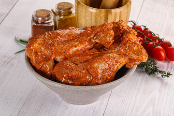 Raw turkey shoulder wing in Indian tandoori marinade