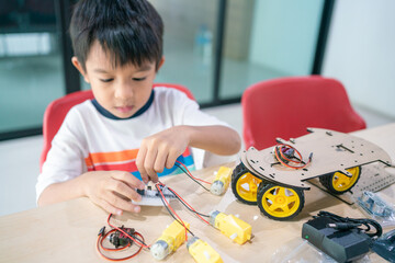 Portrait Of Happy Asian Student Building Arduino Robot Homework Project - 715307652