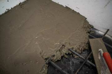 Cement plastering working with   deformed bar metal on wall