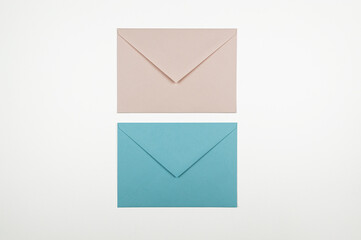 Top view of blue and pink envelopes on white background. Post flat lay. Copy space.