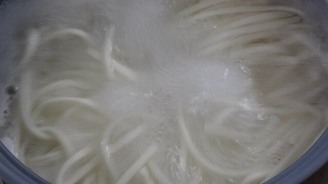 うどんを沸騰したお湯で茹でている調理過程