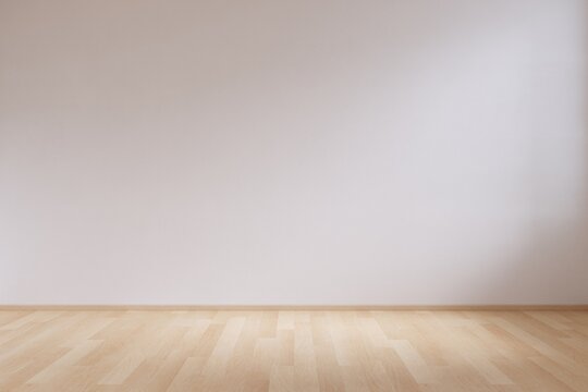 Empty minimalist interior space background with natural light on white wall and wooden floor.